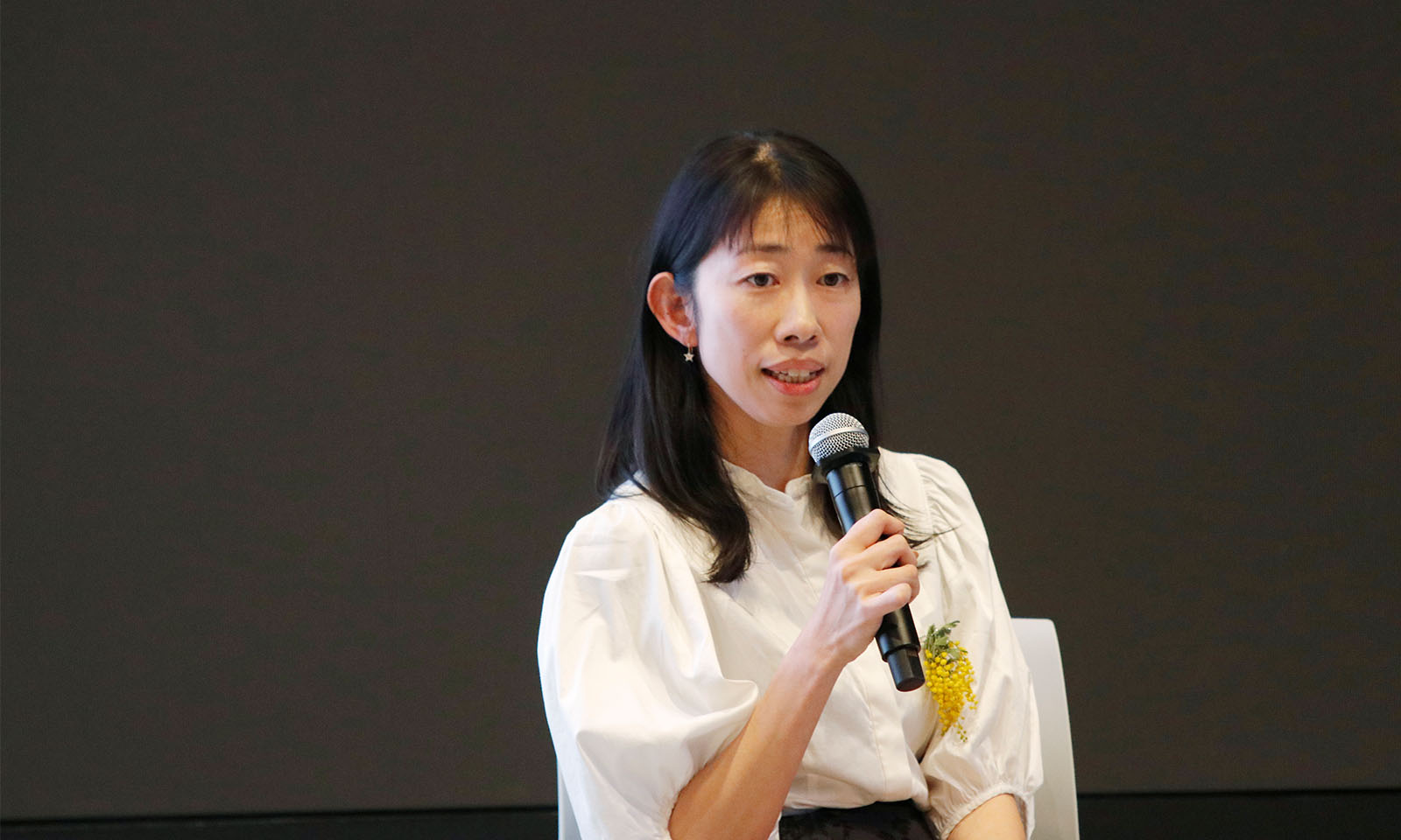 マイクを持ち参加者に語りかけるように話す岩崎さん