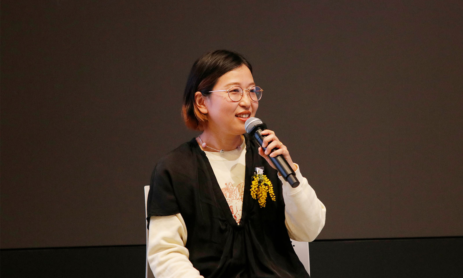 マイクを持ち笑顔で話す鳥居さん